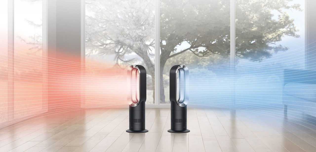 Two Dyson AM09 Hot + Cool Fan Heaters on the floor of a living room, with the left one blowing hot air to the left, and the right one blowing cooling air to the right